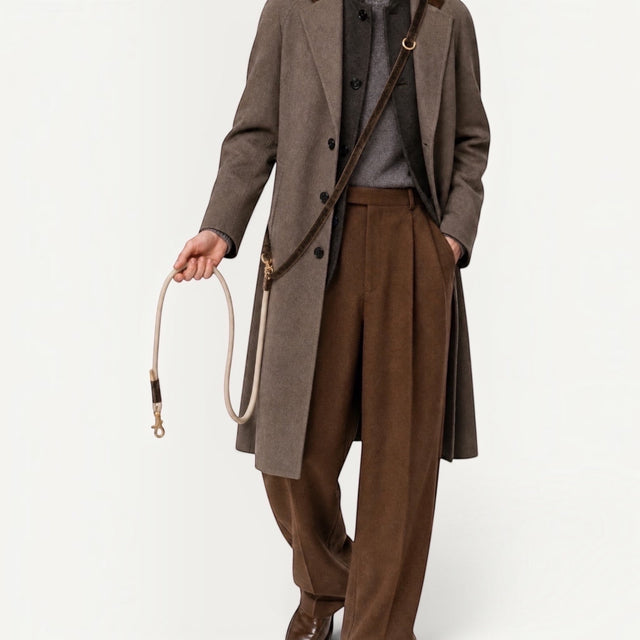 Maison Pupa brown velvet and cream rope dog leash worn crossbody by a man in a brown wool coat and trousers.
