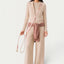 Maison Pupa hands-free dog leash in cream rope and dusty rose velvet worn crossbody by a model in beige knitwear.